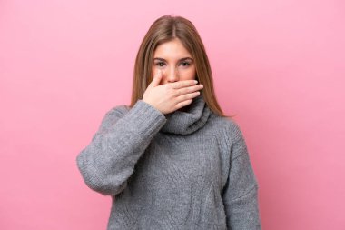 Pembe fırında izole edilmiş genç beyaz kadın ağızlarını eliyle kapatıyor.