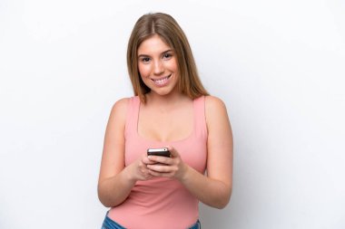 Beyaz bakkalda izole edilmiş genç beyaz kadın cep telefonuyla bir mesaj gönderiyor.