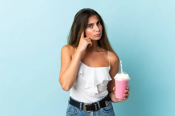 Mujer Joven Con Batido Fresa Aislado Sobre Fondo Azul Pensando —  Fotos de Stock