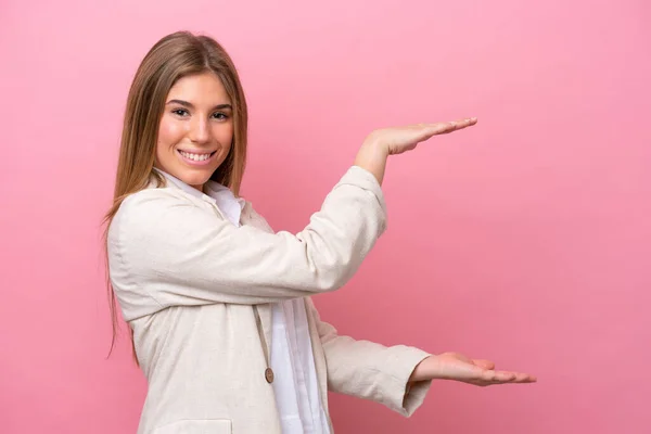 年轻的高加索女人被隔离在粉红色的面包店里 她拿着复制空间插入一个广告 — 图库照片