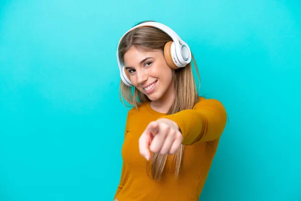 Νεαρή Καυκάσια Γυναίκα Απομονωμένη Μπλε Φόντο Ακούγοντας Μουσική Και Δείχνοντας — Φωτογραφία Αρχείου