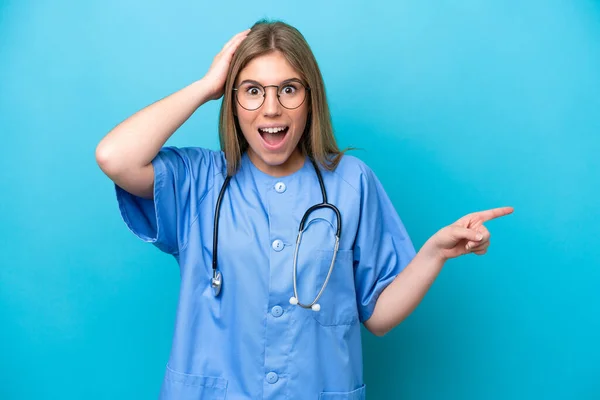 Jonge Chirurg Arts Vrouw Geïsoleerd Blauwe Achtergrond Verrast Wijzend Vinger — Stockfoto
