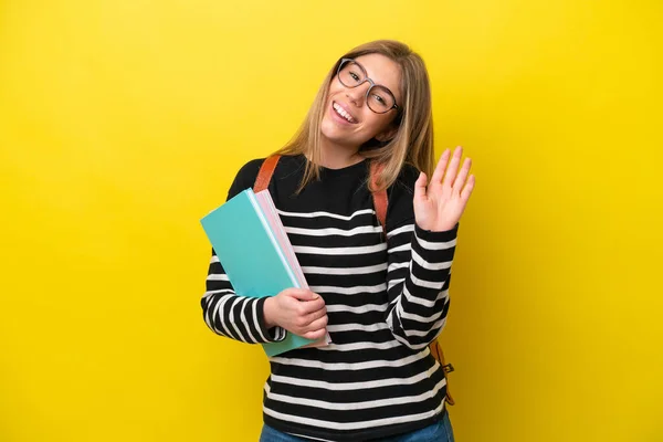 Νεαρή Φοιτήτρια Απομονωμένη Κίτρινο Φόντο Χαιρετά Χέρι Χαρούμενη Έκφραση — Φωτογραφία Αρχείου
