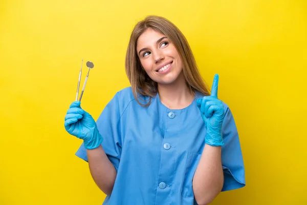 Dentist Caucasian Woman Holding Tools Isolated Yellow Background Pointing Great Stock Picture