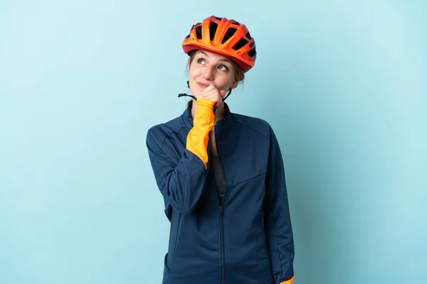 Genç Bisikletçi Kadın Mavi Arka Planda Izole Edilmiş Yukarı Bakıyor — Stok fotoğraf