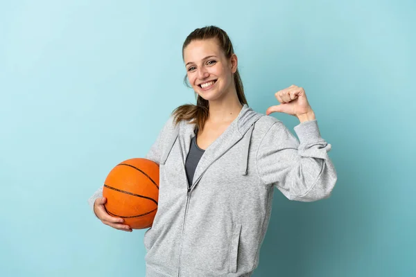 若いです白人女性孤立した上に青の背景にバスケットボールをプレイし 自分自身の誇り — ストック写真
