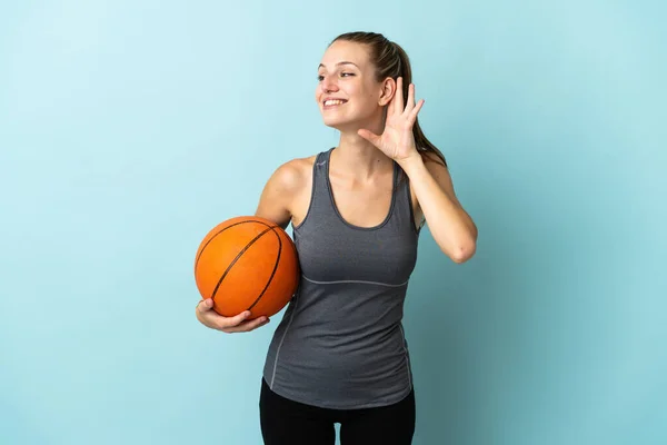 Mladá Žena Hraje Basketbal Izolované Modrém Pozadí Poslech Něco Tím — Stock fotografie