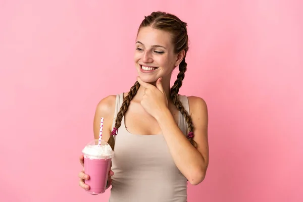 Молодая Женщина Клубничным Молочным Коктейлем Изолированы Розовом Фоне Глядя Сторону — стоковое фото