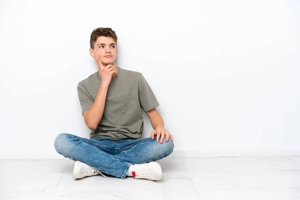 Teenager Ruský Muž Sedí Podlaze Izolované Bílém Pozadí Myšlení Nápad — Stock fotografie