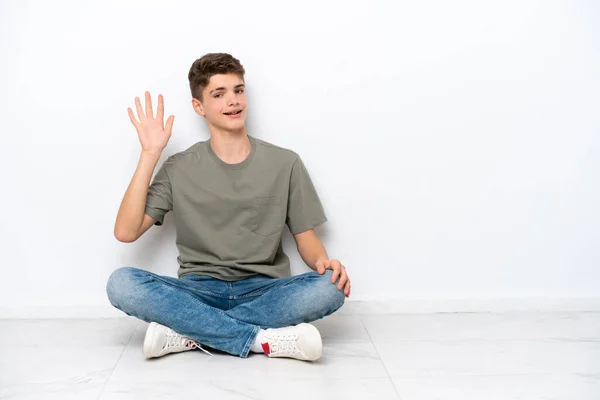 Έφηβος Ρώσος Κάθεται Στο Πάτωμα Απομονωμένος Λευκό Φόντο Χαιρετώντας Χέρι — Φωτογραφία Αρχείου