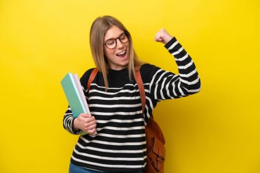 Sarı arka planda izole edilmiş genç bayan bir zaferi kutluyor.