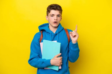 Genç Rus öğrenci, sarı arka planda izole edilmiş bir şekilde parmağını kaldırarak çözümü bulmaya çalışıyor.