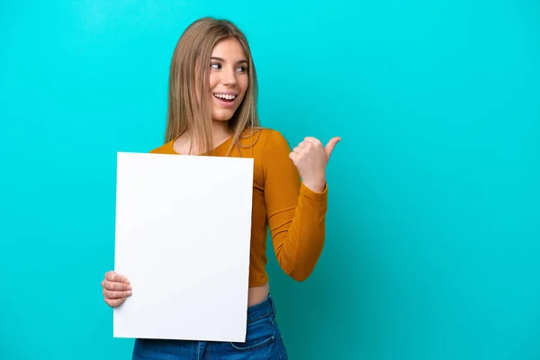 Mulher Caucasiana Jovem Isolado Fundo Azul Segurando Cartaz Vazio Apontando — Fotografia de Stock