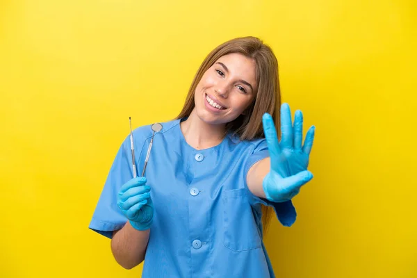Dentista Caucasiano Mulher Segurando Ferramentas Isoladas Fundo Amarelo Feliz Contando — Fotografia de Stock