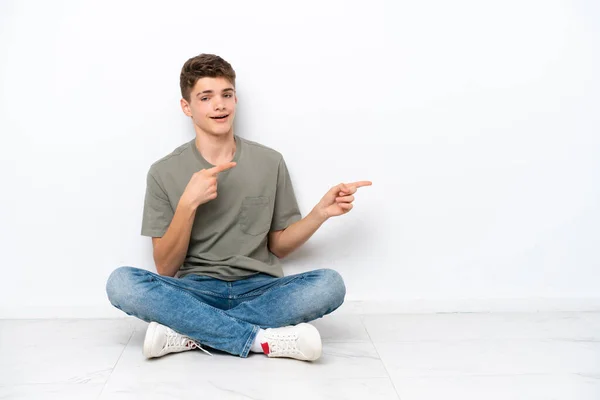 Beyaz Arka Planda Yalnız Oturan Genç Rus Adam Şaşırmış Işaret — Stok fotoğraf