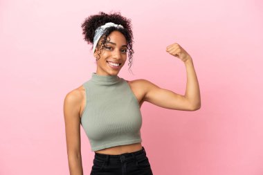 Pembe arka planda izole edilmiş genç Latin kadın güçlü bir jest yapıyor.