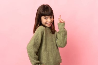 Little girl isolated on pink background showing and lifting a finger in sign of the best