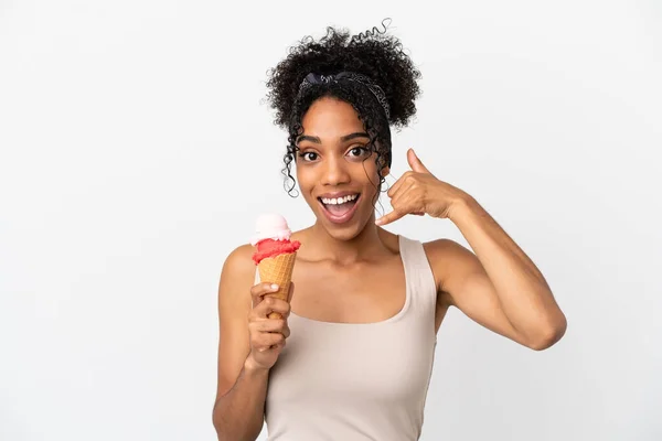 Young african american woman with a cornet ice cream isolated on white background making phone gesture. Call me back sign