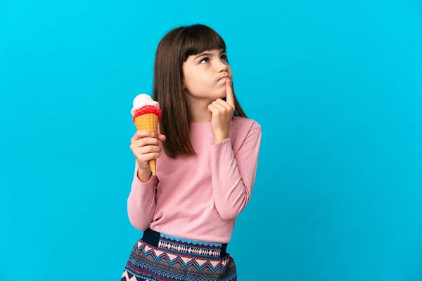 Маленькая Девочка Корнетным Мороженым Изолированным Синем Фоне Испытывает Сомнения Глядя — стоковое фото