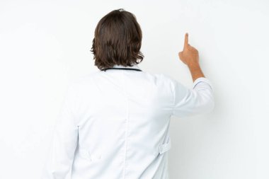 Üst düzey Hollandalı, beyaz arka planda izole edilmiş, doktor önlüğü giymiş ve arkasını işaret ediyor.