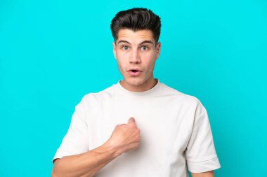 Genç, beyaz, mavi fırında izole edilmiş bir adam kendini işaret ediyor.