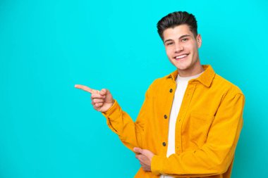 Genç, yakışıklı, beyaz bir adam, mavi bir bakkalda izole edilmiş.