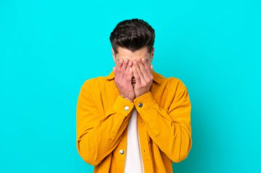 Genç, yakışıklı, beyaz bir adam mavi fırında izole edilmiş, yorgun ve hasta bir yüz ifadesi var.