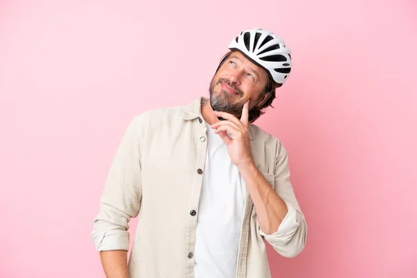 Homem Holandês Sênior Com Capacete Bicicleta Isolado Fundo Rosa Pensando — Fotografia de Stock