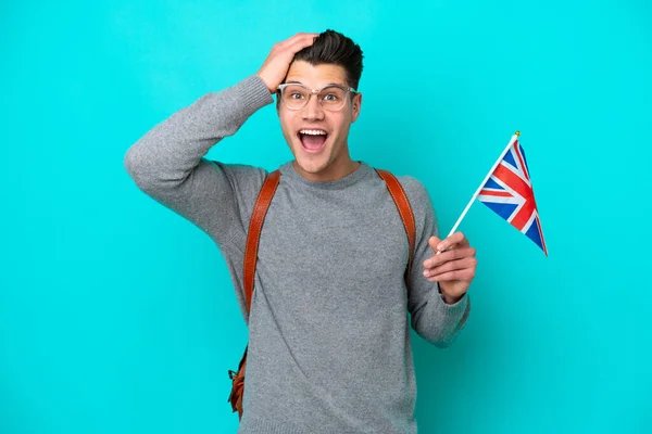 青地にイギリス国旗を掲揚している若い白人男性は驚きの表情で — ストック写真