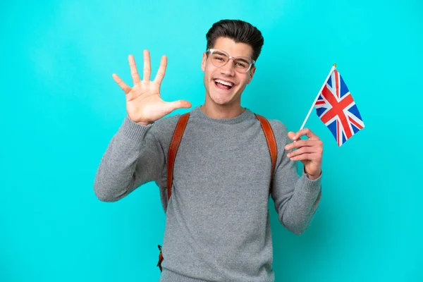 青い背景に5本指で数えるイギリス国旗を持っている若い白人男性 — ストック写真