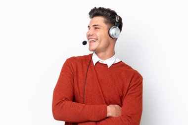 Beyaz arka planda izole edilmiş, mutlu ve gülümseyen bir kulaklıkla çalışan beyaz pazarlamacı.