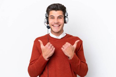 Tele pazarlamacı, beyaz arka planda izole edilmiş kulaklıkla çalışan beyaz bir adam. Baş parmak hareketleriyle ve gülümsemesiyle.