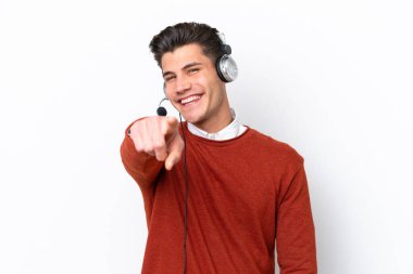 Beyaz arka planda izole edilmiş kulaklıkla çalışan beyaz pazarlamacı beyaz adam kendine güvenen bir ifadeyle sana parmak basıyor.