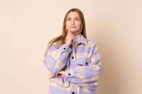 Tonåring Ukrainska Flicka Isolerad Beige Bakgrund Med Tvivel När Tittar — Stockfoto