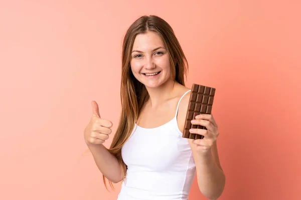 Teenager Ukrainian Girl Isolated Pink Background Taking Chocolate Tablet Thumb — Stock Photo, Image