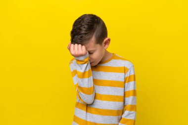 Küçük beyaz çocuk sarı arka planda başağrısı ile izole edilmiş.