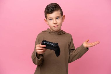 Pembe arka planda izole edilmiş bir bilgisayar oyunu kontrolörüyle oynayan beyaz çocuk ellerini kaldırırken şüpheye düşüyor.