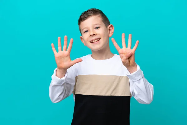 一个蓝色背景的小男孩用手指数着9 — 图库照片