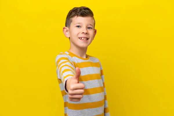 一个带着大拇指的白人小男孩在黄色背景上被隔离了 因为发生了件好事 — 图库照片