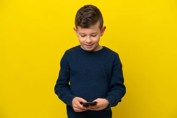 Little Caucasian Boy Isolated Yellow Background Sending Message Mobile — Stock Photo, Image