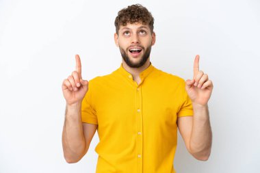 Beyaz arka planda izole edilmiş yakışıklı beyaz adam şaşırmış ve yukarı bakıyor.