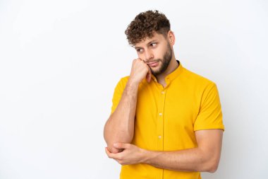 Beyaz arka planda soyutlanmış, yorgun ve sıkılmış bir ifadeyle yakışıklı beyaz bir adam.