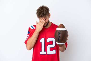 Beyaz arka planda ragbi oynayan genç beyaz bir adam yorgun ve hasta bir ifadeyle izole edilmiş.