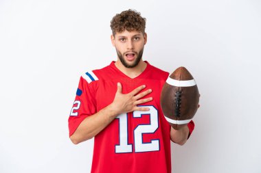 Beyaz arka planda ragbi oynayan genç beyaz bir adam sağa bakarken şaşırmış ve şok olmuştu.