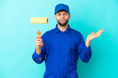 Kafkasyalı ressam mavi arka planda izole edilmiş ve el kaldırırken şüpheleri var.
