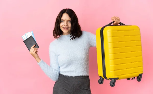 ティーンウクライナ人女の子隔離上のピンクの背景不幸な休暇でスーツケースとパスポート — ストック写真