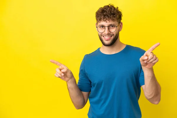 Mladý Pohledný Běloch Izolovaný Žlutém Pozadí Ukazující Prstem Laterály Šťastný — Stock fotografie