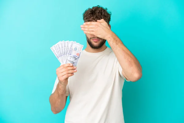 Joven Hombre Caucásico Tomando Montón Dinero Aislado Sobre Fondo Azul — Foto de Stock