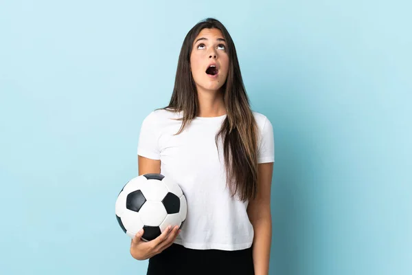 Młody Piłkarz Brazylijski Dziewczyna Odizolowany Niebieskim Tle Patrząc Górę Zaskoczeniem — Zdjęcie stockowe