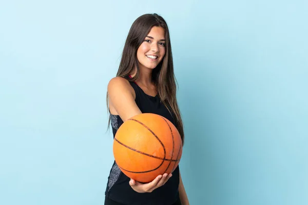 被蓝色背景隔离的年轻巴西女孩打篮球 — 图库照片